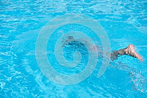 Boy in diving mask swim underwater in the swimming pool