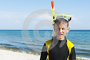 Boy in divingsuit and mask and snorkel at sea background