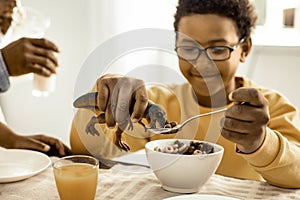 Boy do not eating flakes himself, but forcing a toy.