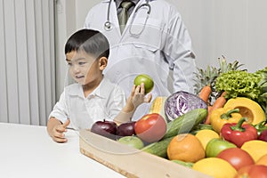 A boy and doctor happy to have healthy food. Kid learning about nutrition with doctor to choose eating fresh fruits and vegetables