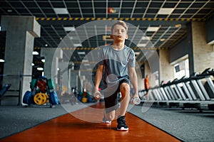 Boy doing exercise with dumbbells in gym