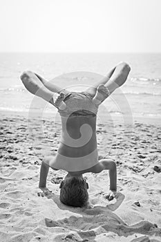 Boy doing a handstand on the beach