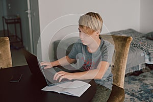 boy doing his homework at desk indoors