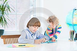 Boy doing homework and his sister watching him photo