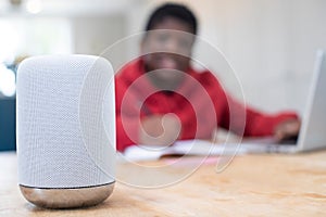 Boy Doing Homework At Home Asking Digital Assistant Question