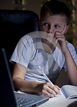 Boy doing homework with laptop