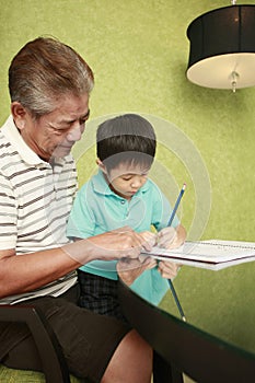 Boy doing homework, man watching. Conceptual image