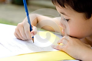 Boy doing homework, outdoors