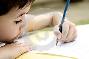 Boy doing homework, outdoors.