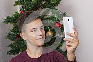 Boy doing selfie near New Year tree