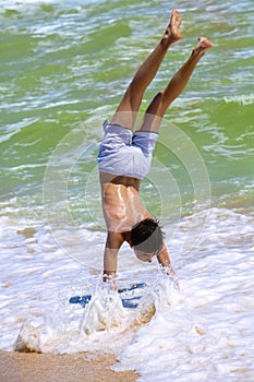 Boy doing somersaults on seacoast
