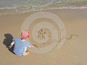 Boy draw on beach