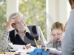 Boy Drawing With Crayons With Father And Grandfather