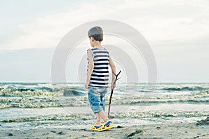 Boy drawing on sand at seaside. Child drawing sand by imaginary on beach for learning