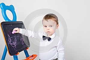 Boy draws a chalk on a board