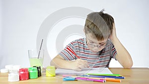 Boy draws a picture of a pencil