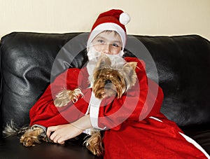 The boy in the dress Santa Claus poses with a little dog