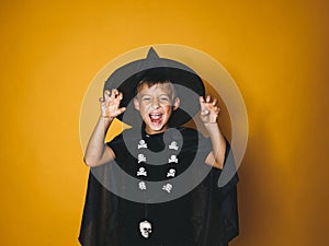 Boy is dressed as a halloween witcher in front of orange background