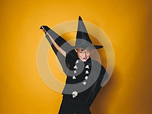 Boy is dressed as a halloween witcher in front of orange background