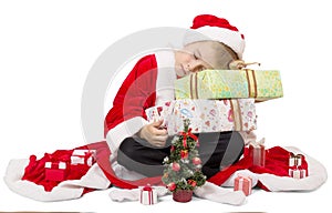 Boy dressed as Santa sleeping on Christmas gift