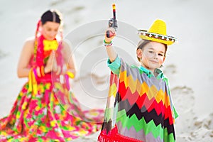 Boy dressed in Mexican costume and holding a toy