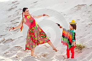 Boy dressed in Mexican costume holding a toy gun