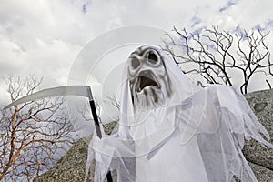 Boy dressed up as grim reaper holding scythe