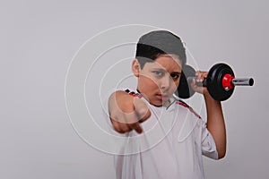 A sporty boy using gym weights with a challenging look