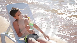 Boy drinking cocktail on tropical beach