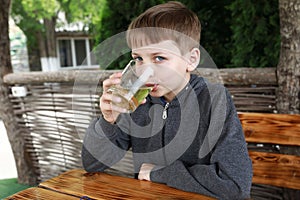 Boy drinking juice on restaurant terrace