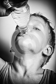 Boy is drinking mineral water from bottle