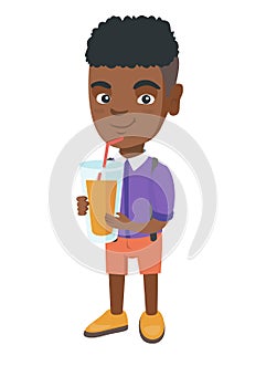 Boy drinking orange juice through a straw.