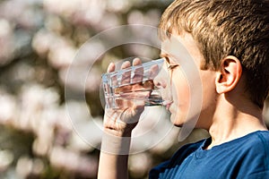 Boy drinking pure water from glass photo
