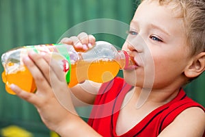 Boy drinking unhealthy bottled soda