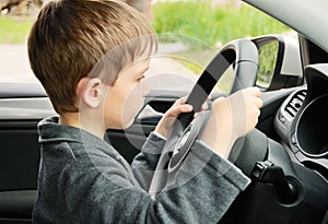 Boy driving a car and looking at the way