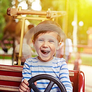 Boy driving a car on merry-go-round