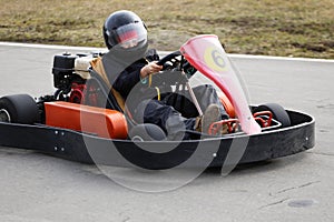 Boy is driving Go-kart car with speed in a playground racing track