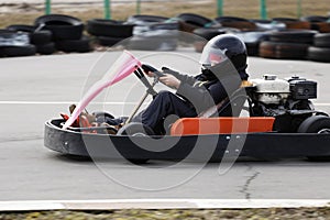 Boy is driving Go-kart car with speed in a playground racing track