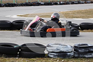 Boy is driving Go-kart car with speed in a playground racing track