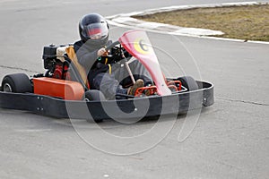 Boy is driving Go-kart car with speed in a playground racing track