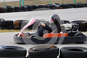 Boy is driving Go-kart car with speed in a playground racing track