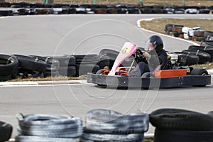 Boy is driving Go-kart car with speed in a playground racing track
