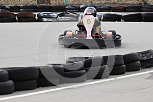 Boy is driving Go-kart car with speed in a playground racing track