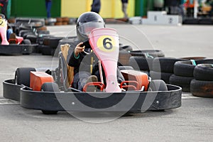 Boy is driving Go-kart car with speed in a playground racing track