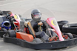 Boy is driving Go-kart car with speed in a playground racing track