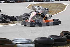 Boy is driving Go-kart car with speed in a playground racing track