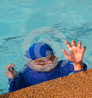 A boy drowning in the pool.