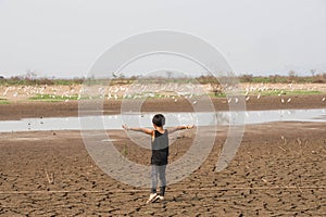 Boy in dryland looking at drought landscape. Concept for climate change from global worming.