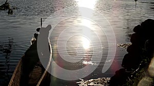 Boy earns living as fisherman in a lake using boat. silhouettes