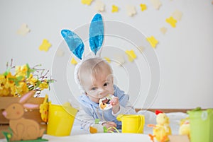 Boy with Easter bunny ears and colorful eggs and flowers
